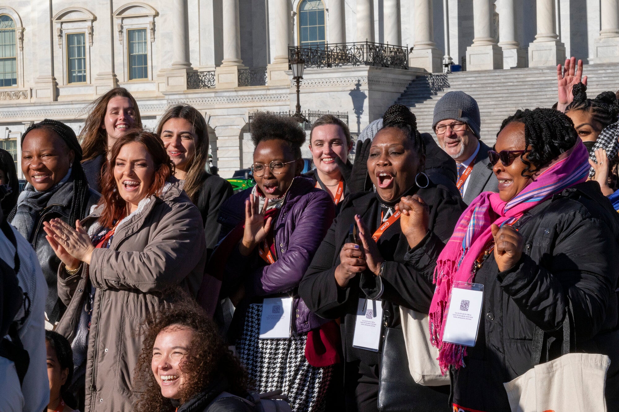 Un groupe de personnes applaudissant à l'extérieur du bâtiment du Capitole des États-Unis