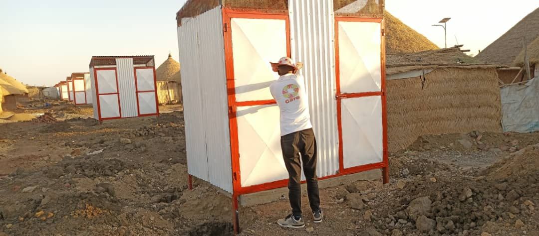 Aid worker installs a temporary toilet
