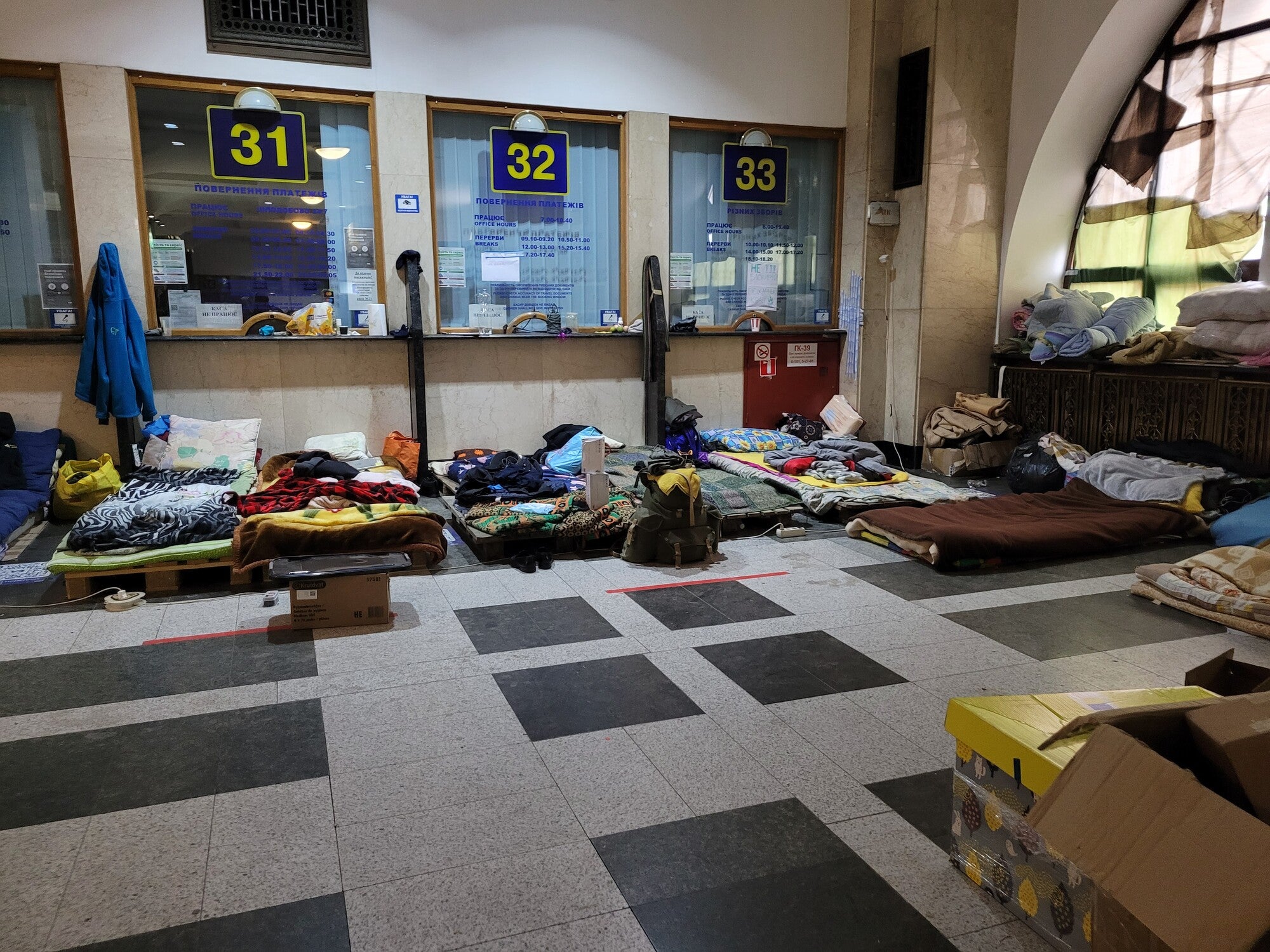 Makeshift beds inside the ticketing area of a train station.