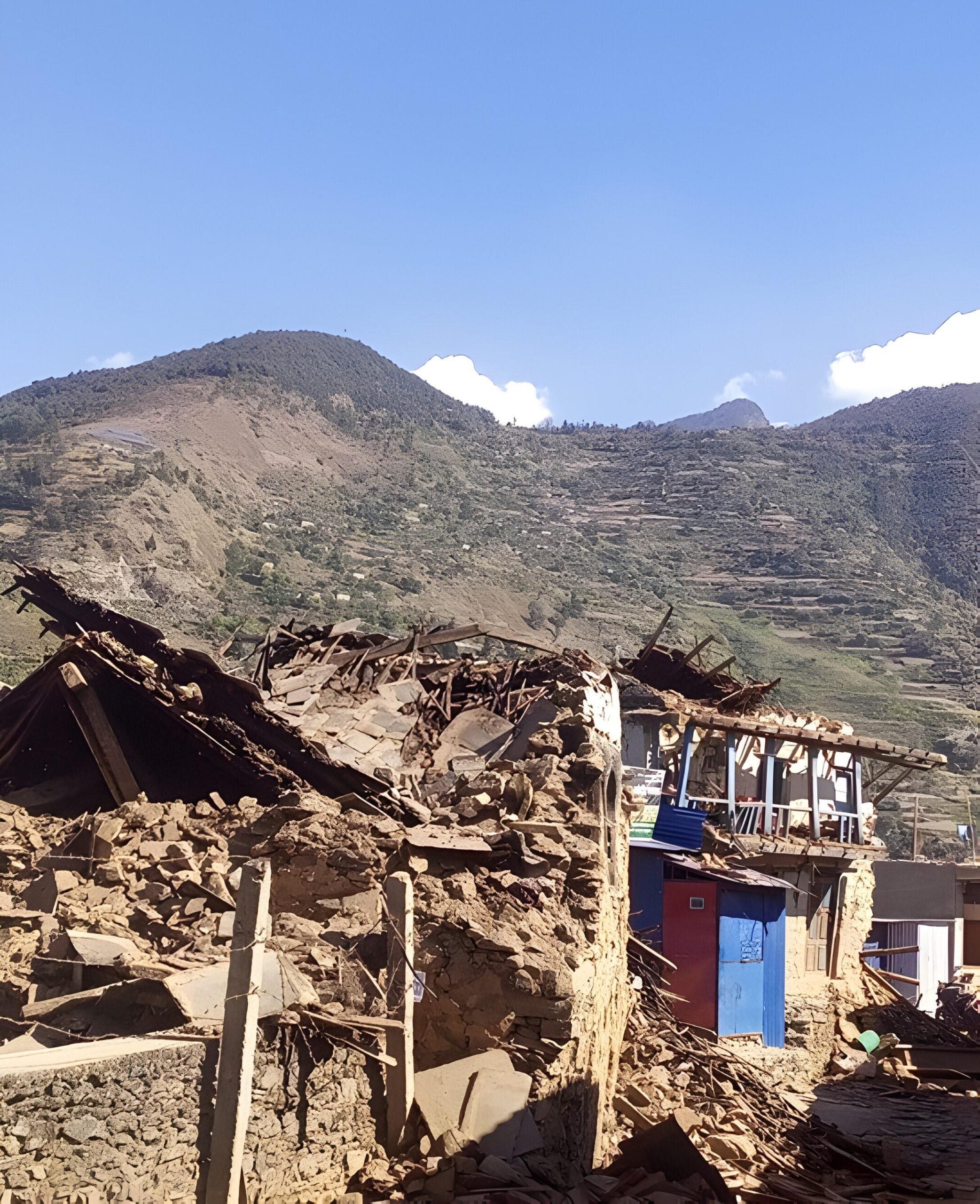 Image of damaged homes with mountain range in the background