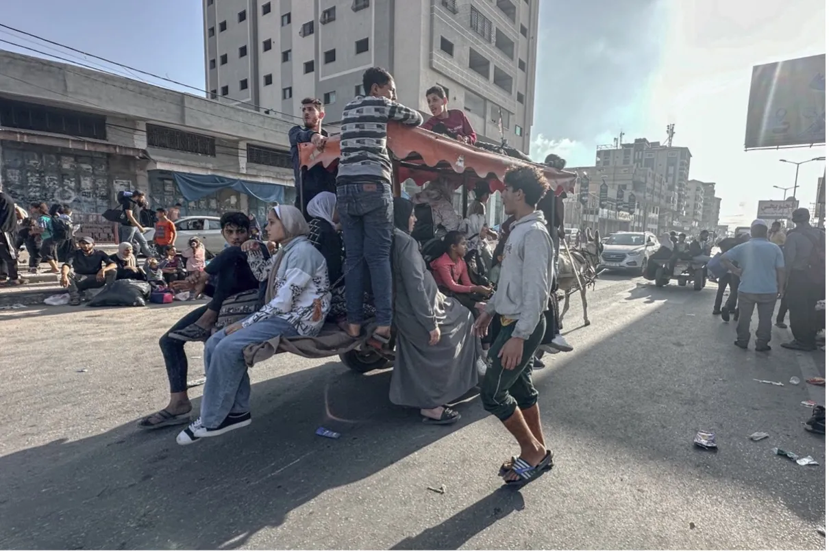 Young people crowding onto a cart pulled by a donkey in the middle of the street.
