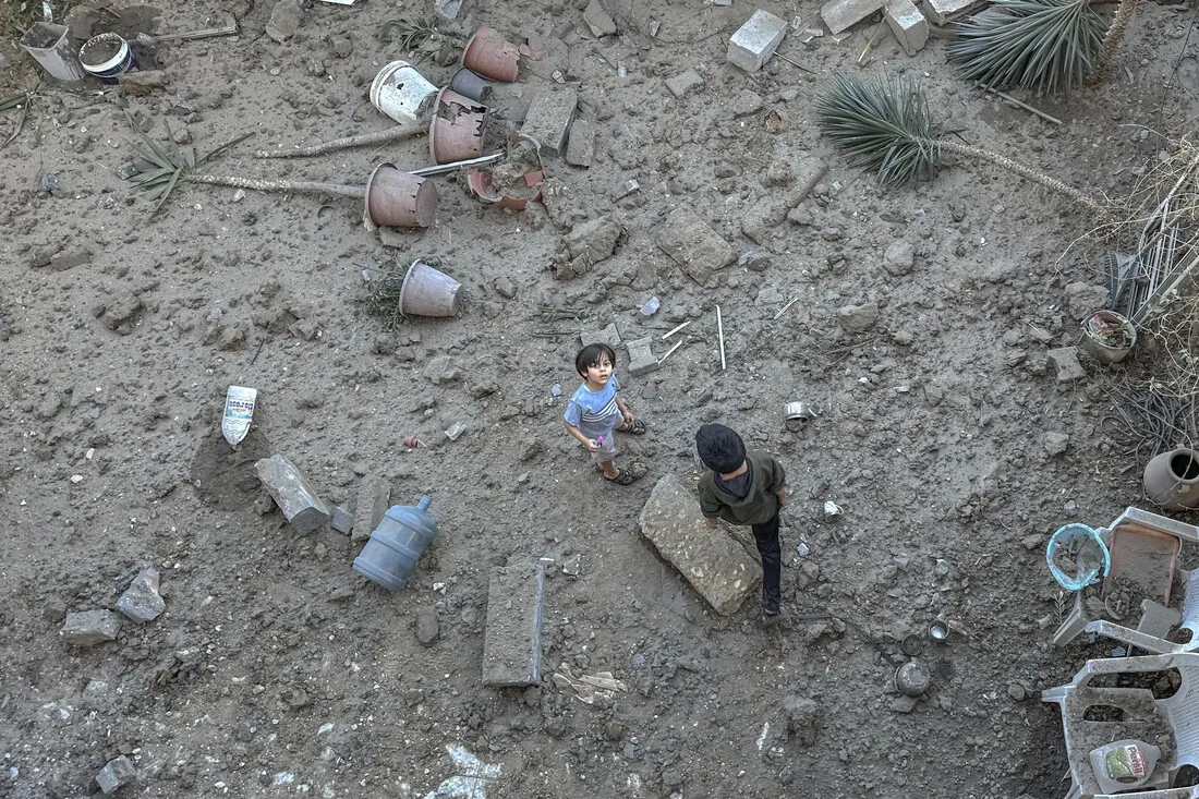 A Palestinian boy stands on the debris of his family's destroyed house.