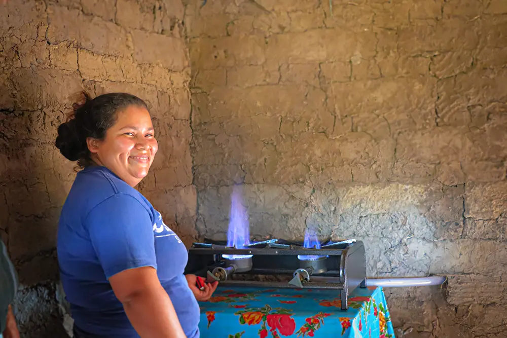 A Honduran woman shows the biodigester in her home.