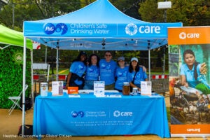 CARE staff and volunteers standing together at their Global Citizen booth
