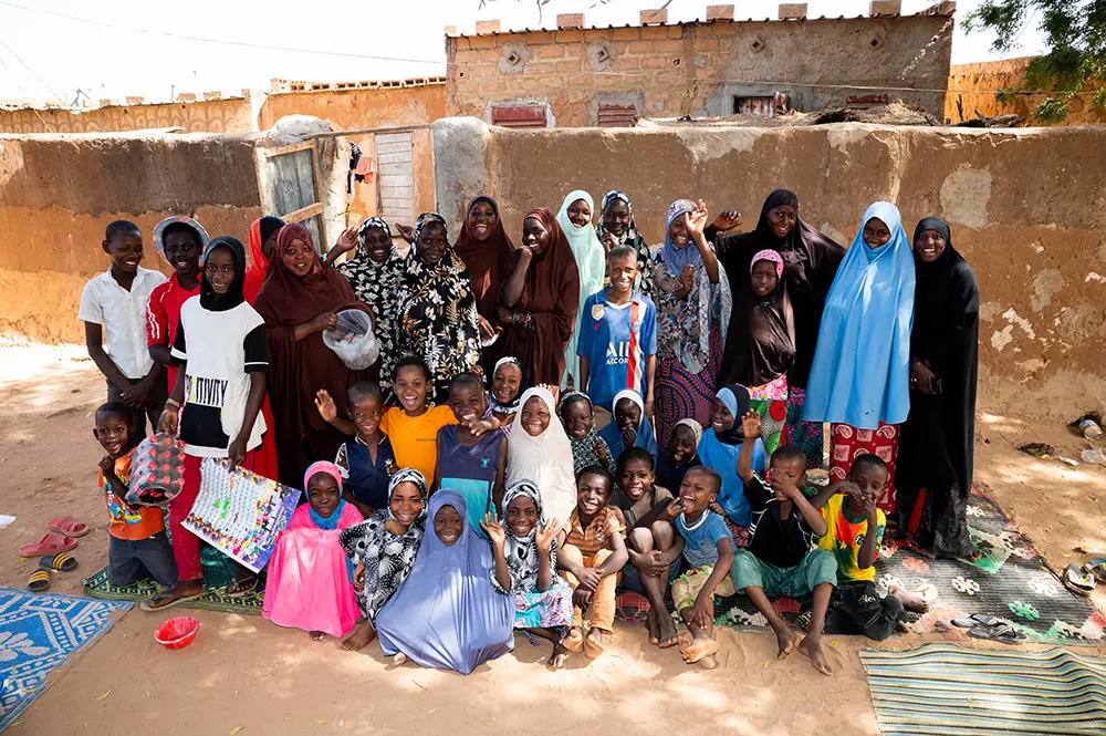 A large group of Nigerien children gather together and smile.