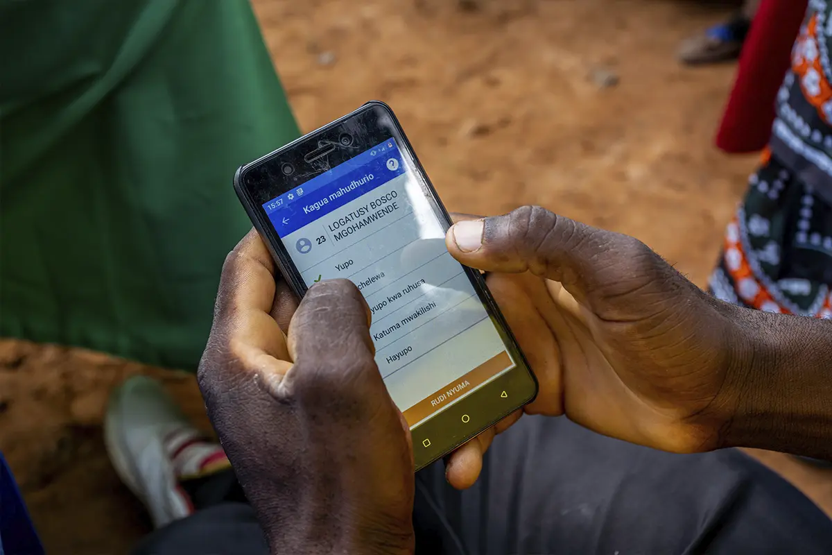 A close-up of a person typing while using a mobile app on their cell phone.