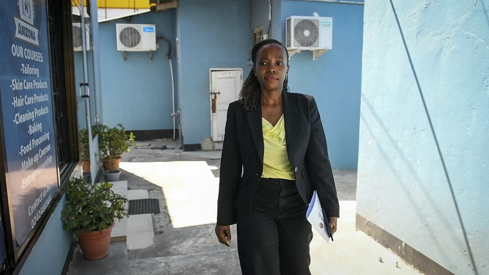 A Tanzanian woman in her 30s walks to work in Dar es Salaam.