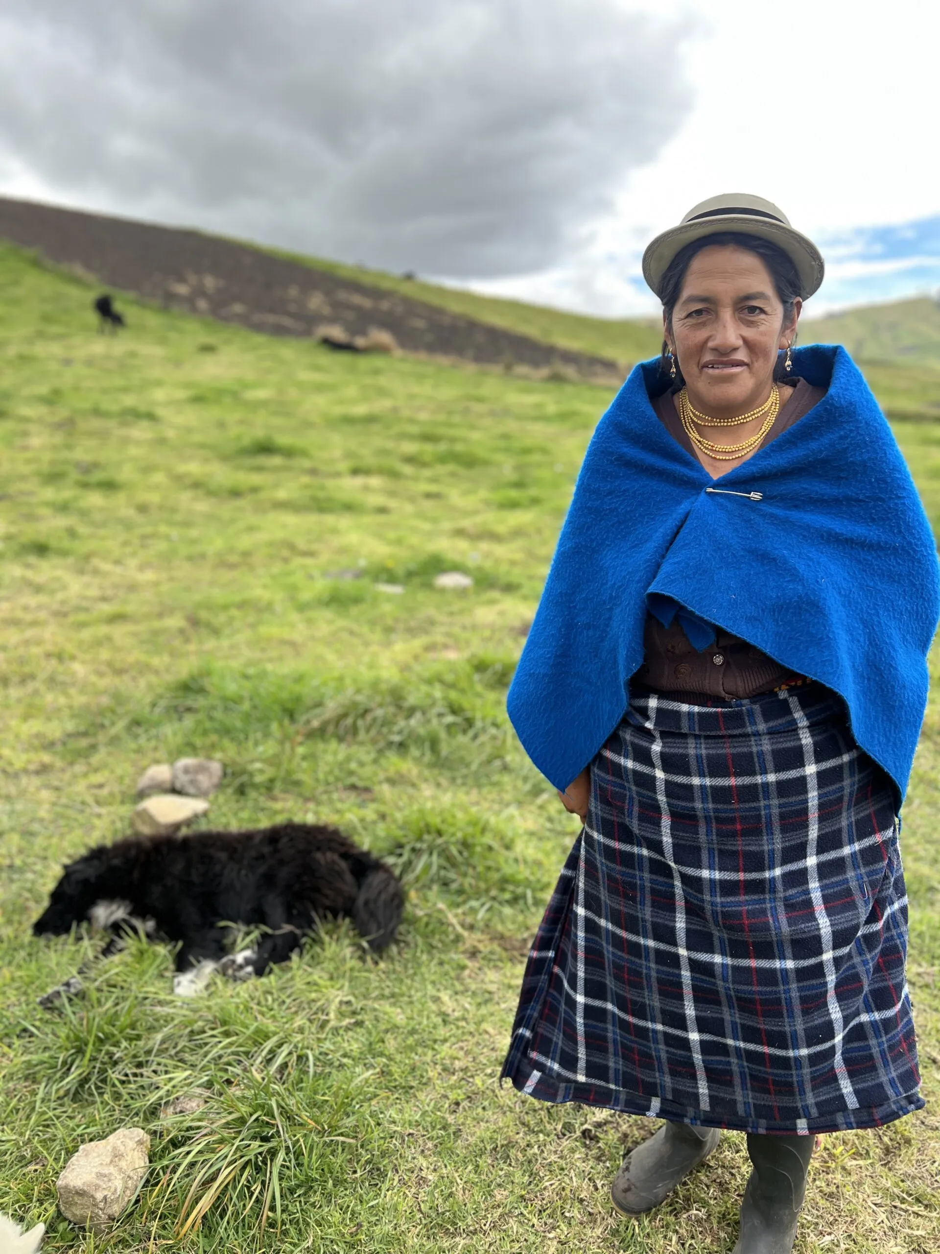 An indigenous woman farmer in San Juan, Peru. She wears an indigo wool wrap around her shoulders.