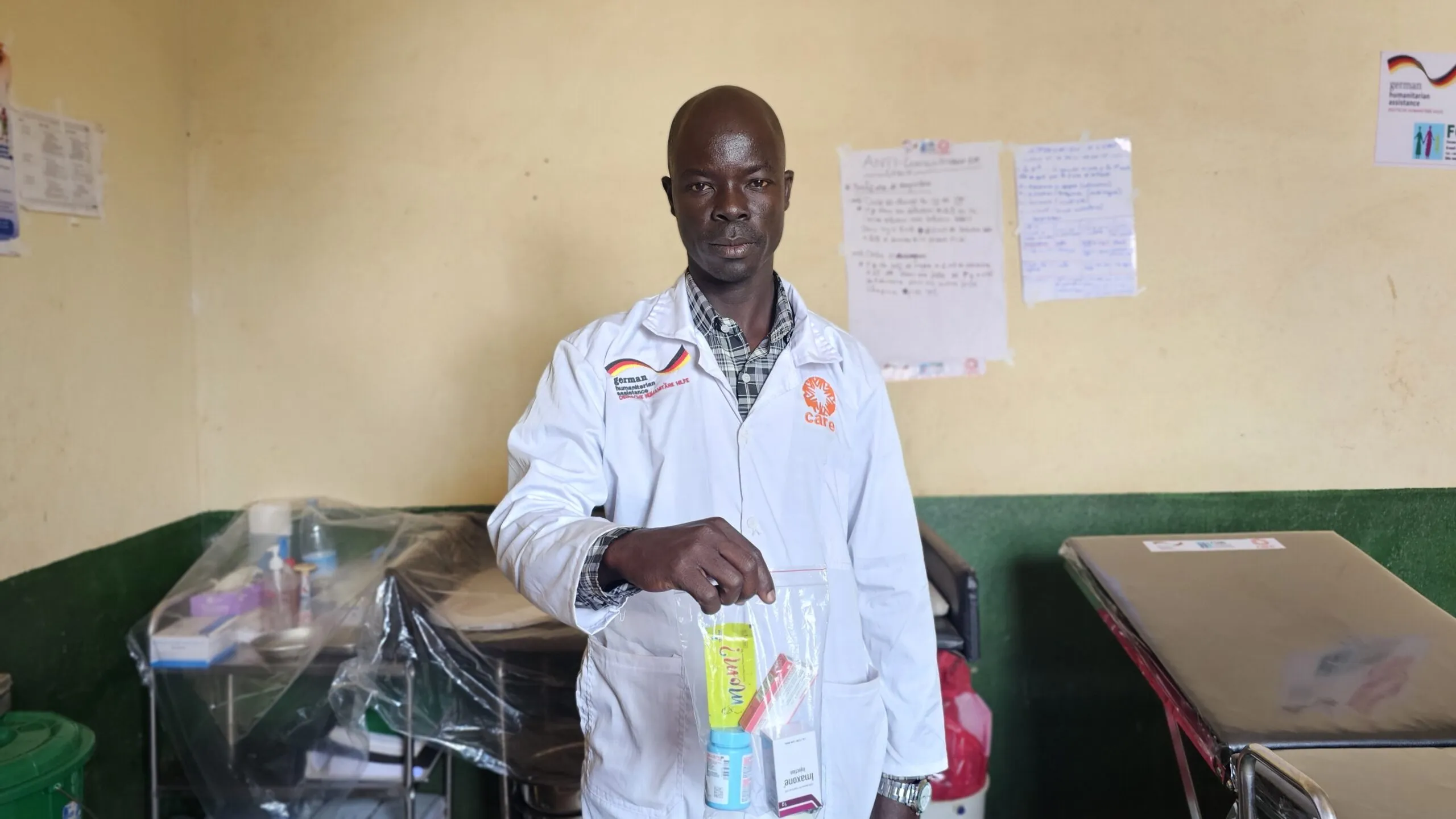 A healthcare worker at a clinic in DRC holds up a clear plastic bag containing a PEP kit used for survivors of sexual assault.