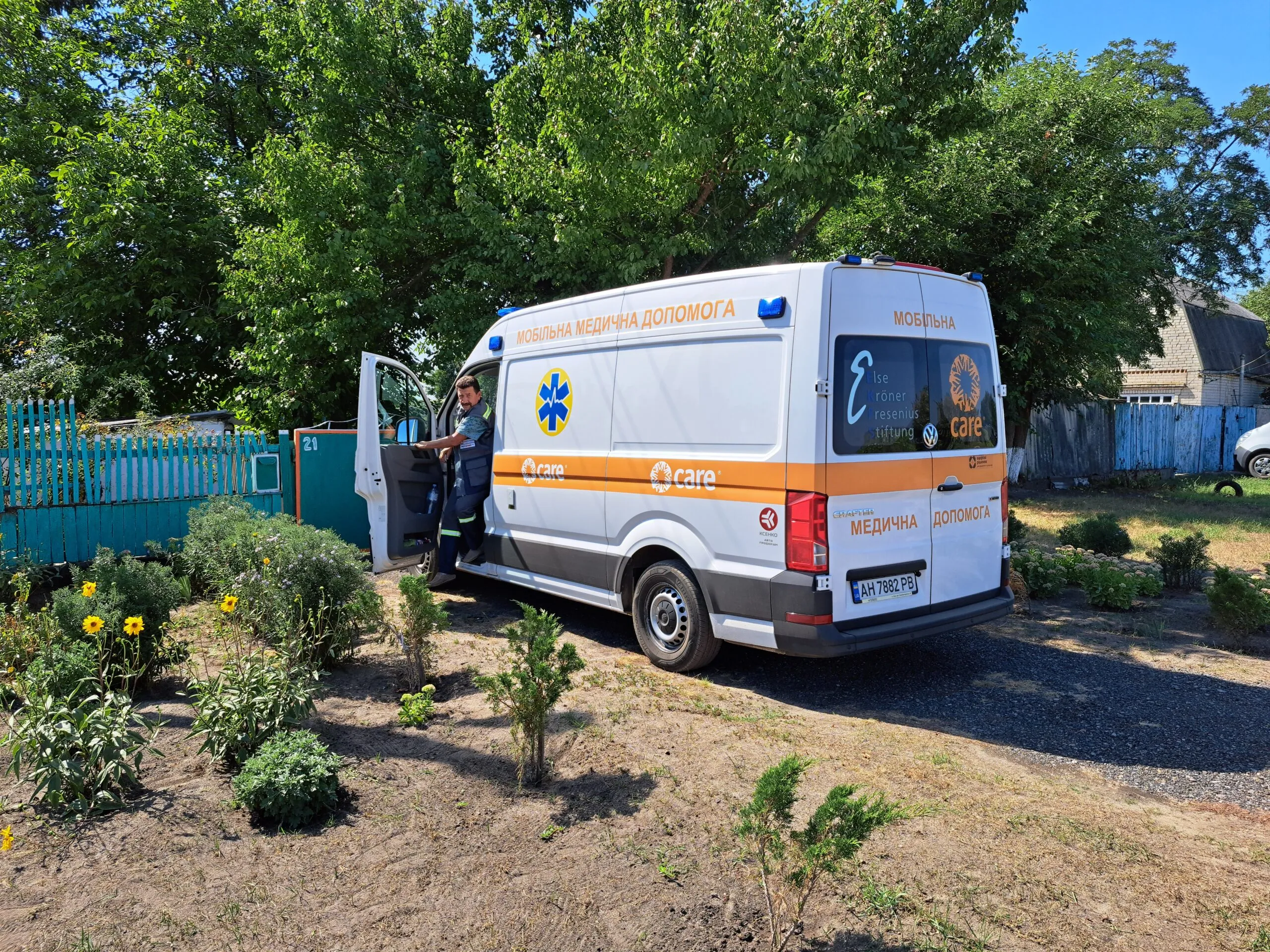 A man opens the door of a CARE branded ambulance and mobile care clinic in Kramatorsk, Ukraine.