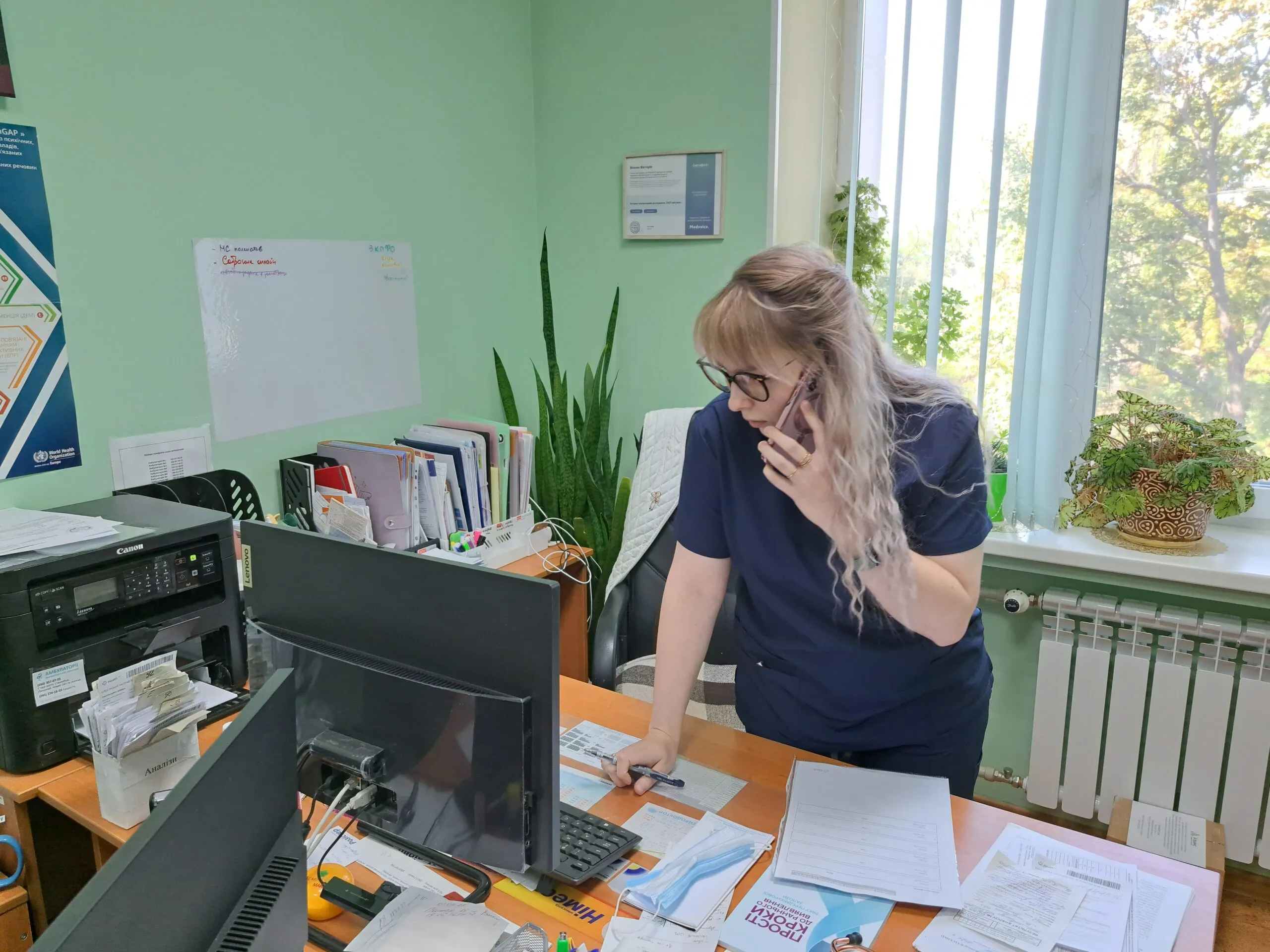 A health care professional speaks into her cell phone as she tries to coordinate a visitation schedule in Ukraine.