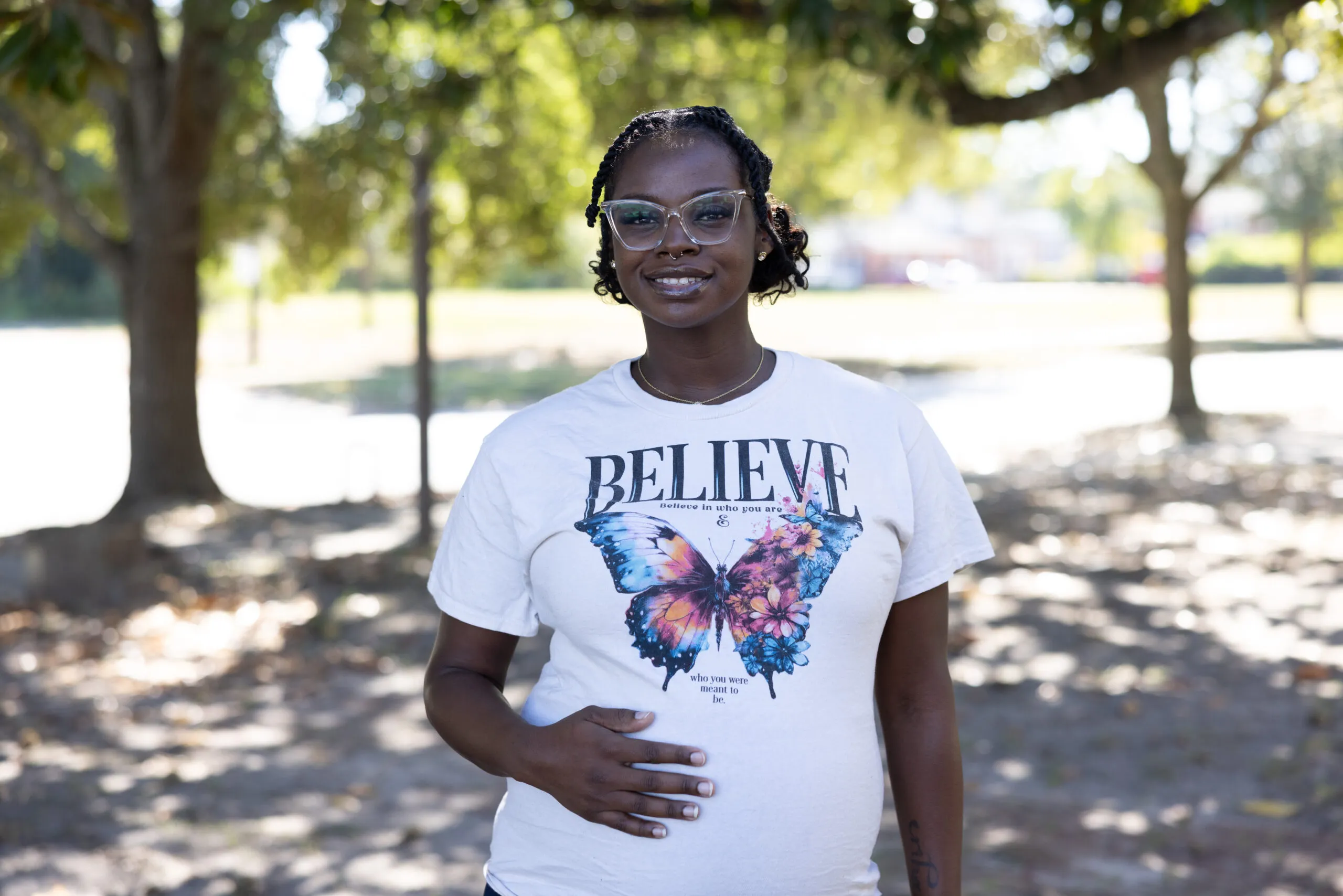Pregnant mother smiles and places hand on her stomach
