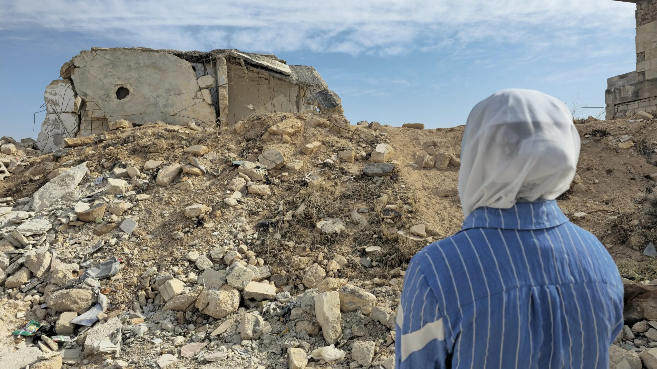 Young woman watching her destroyed home in Syria