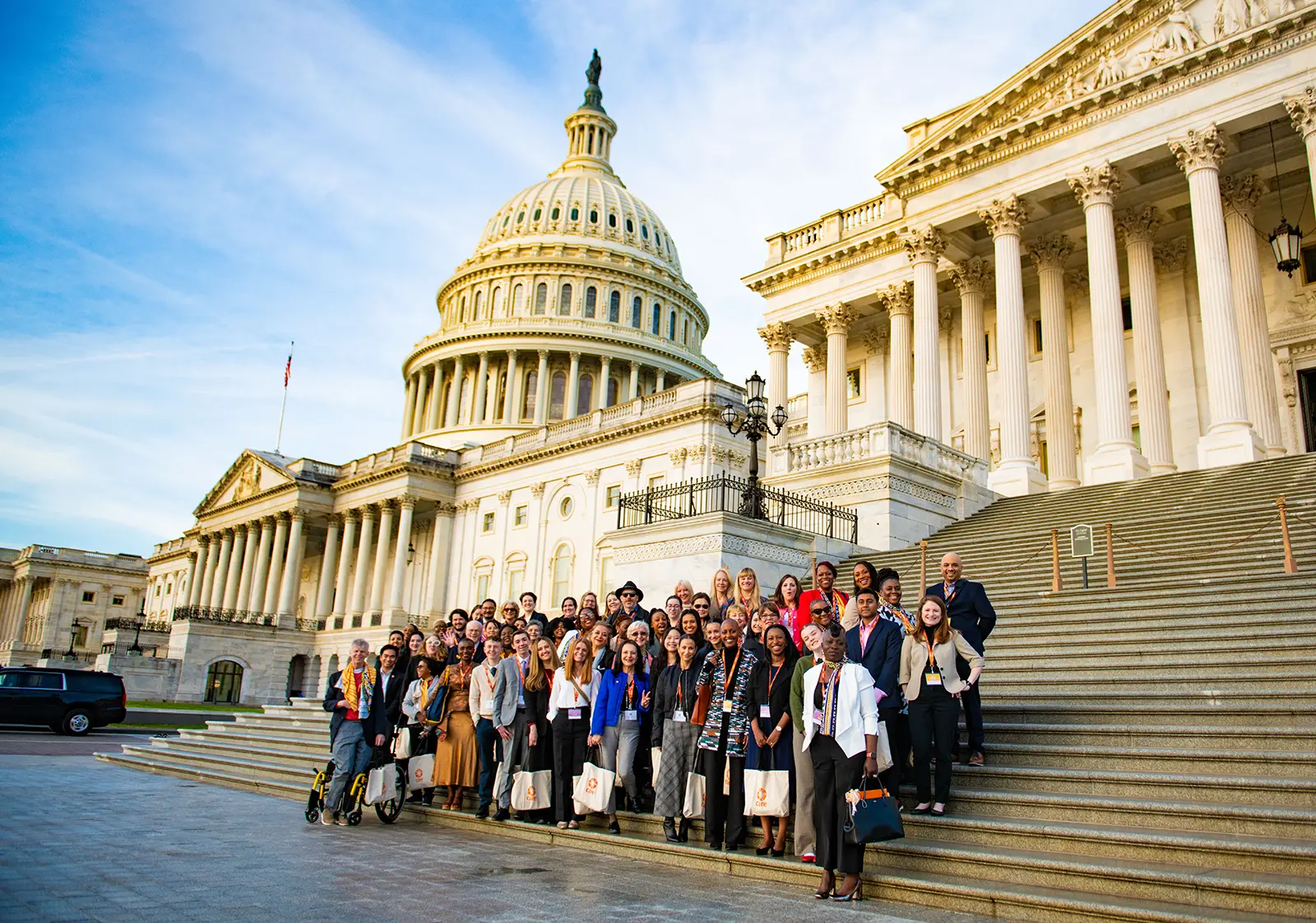 A group of CARE supporters stand in front of the U.S. Capitol building.