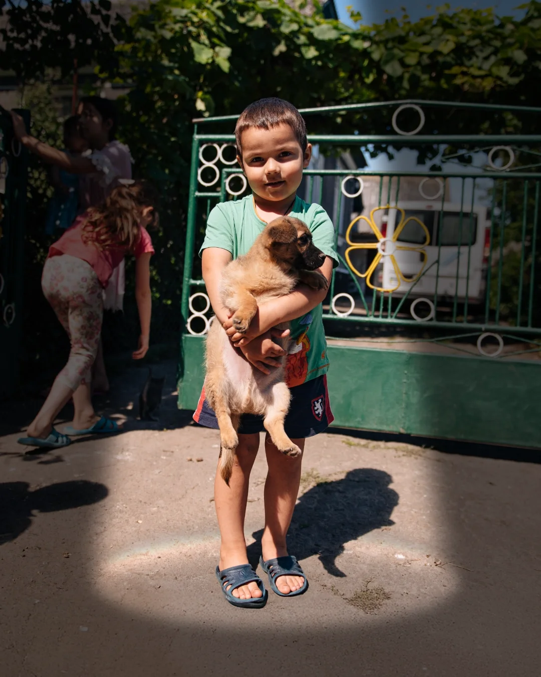 A young Ukrainian boy holds a puppy.