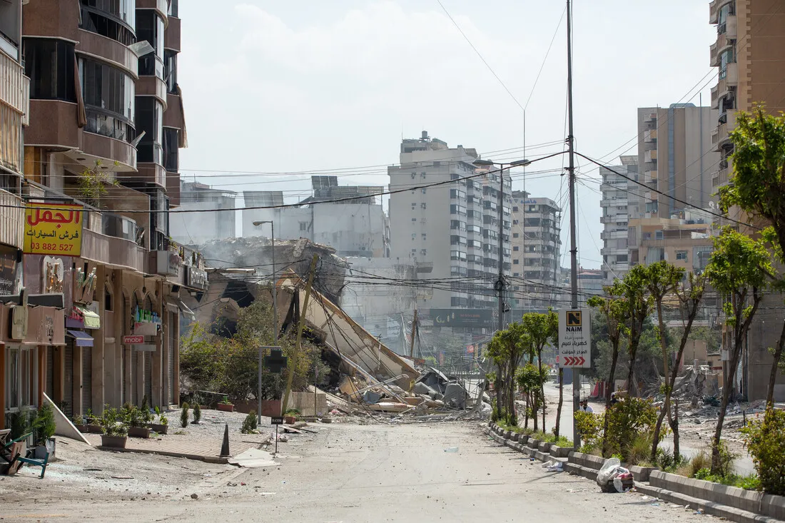 Urban street with damaged buildings and rubble. Skyscrapers in the background, debris scattered, conveying a sense of destruction and abandonment.