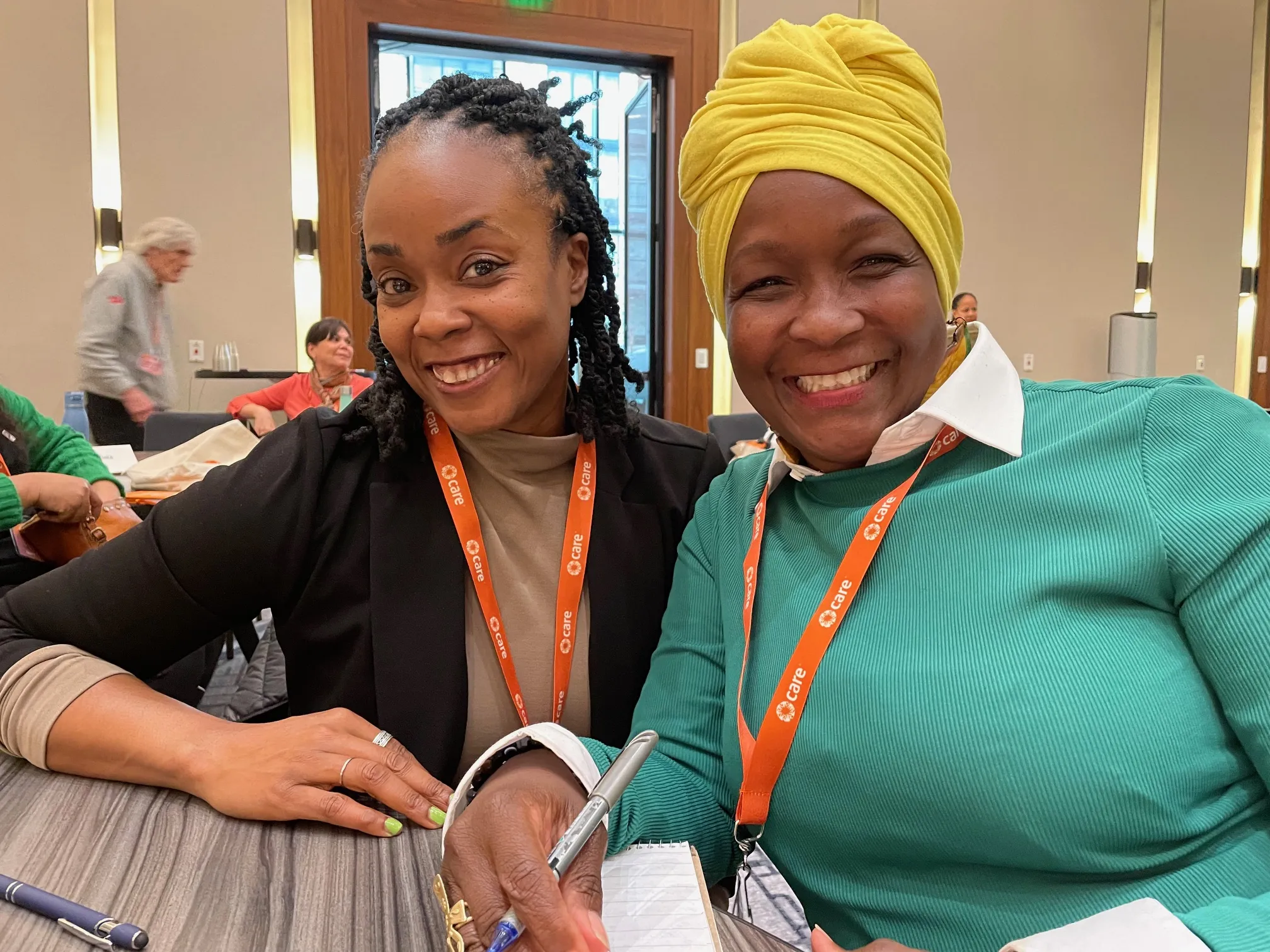 Two women advocates wear CARE lanyards in a meeting with their representative on Capitol Hill during a CARE event.