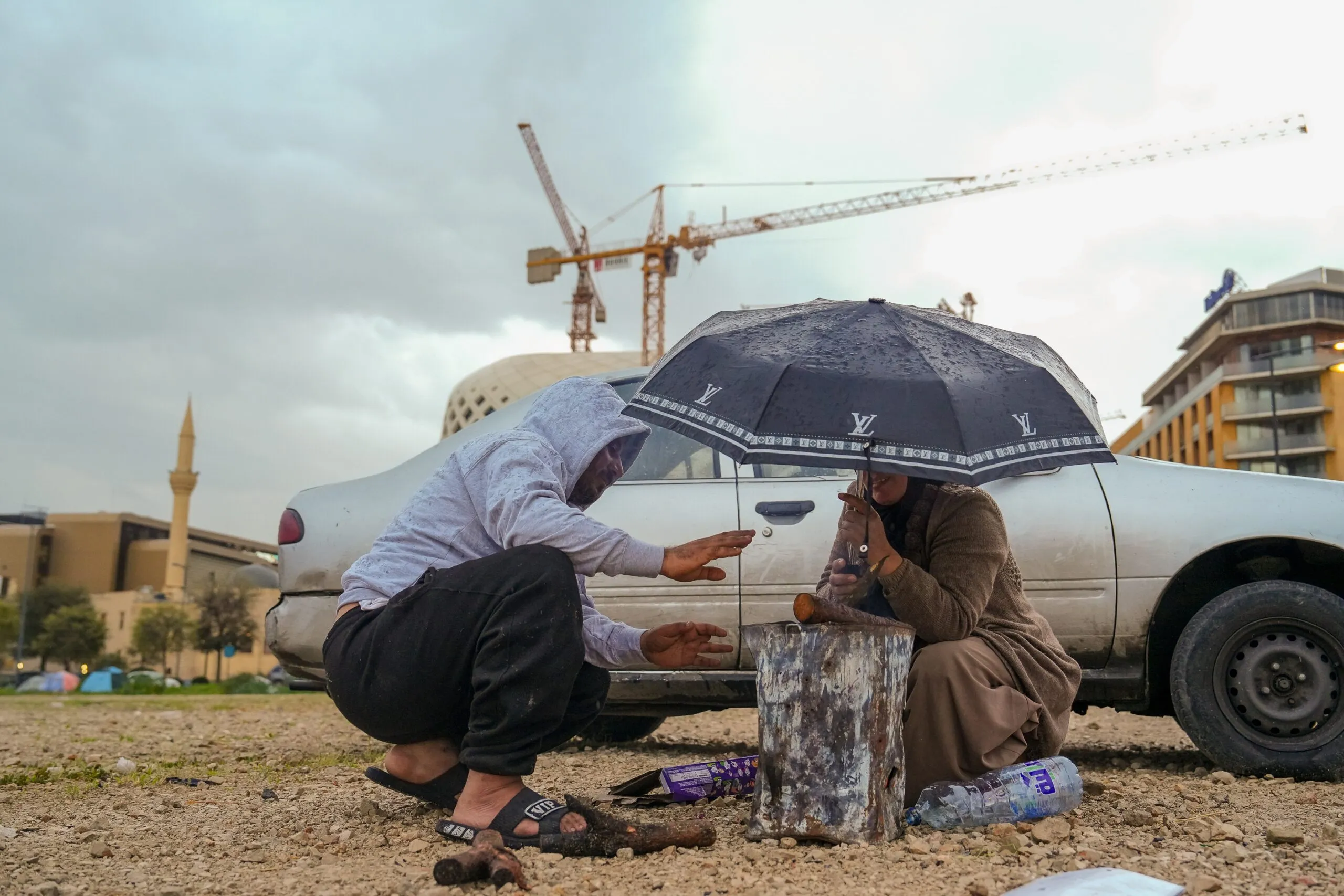 A man and woman huddle around a makeshift fire in Lebanon.
