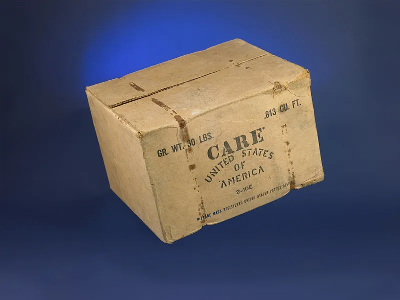 An original CARE PACKAGE, cardboard box, sitting inside the Smithsonian Museum of American History.