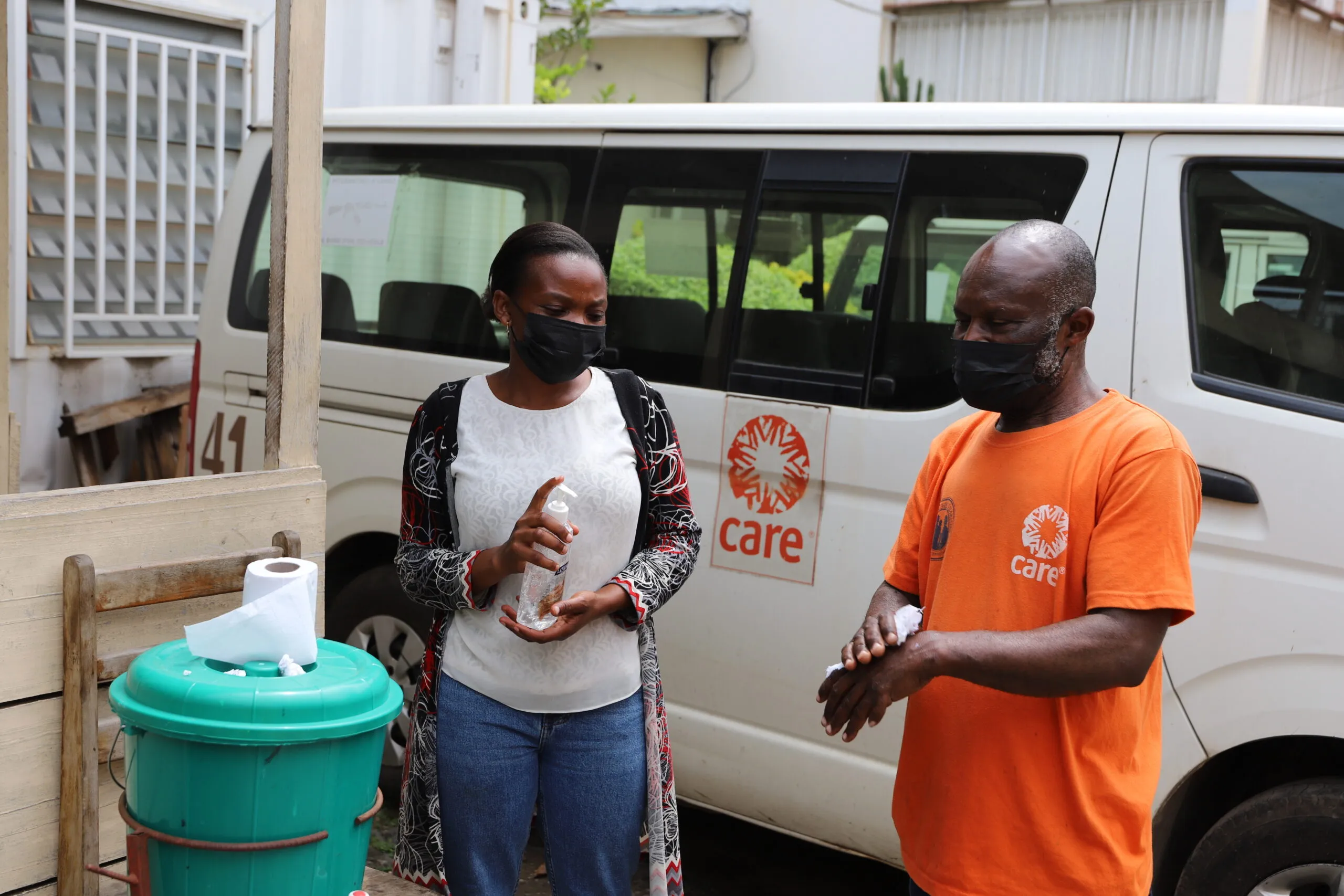 CARE DRC staff members wash their hands at an outdoor hygiene station in Goma.