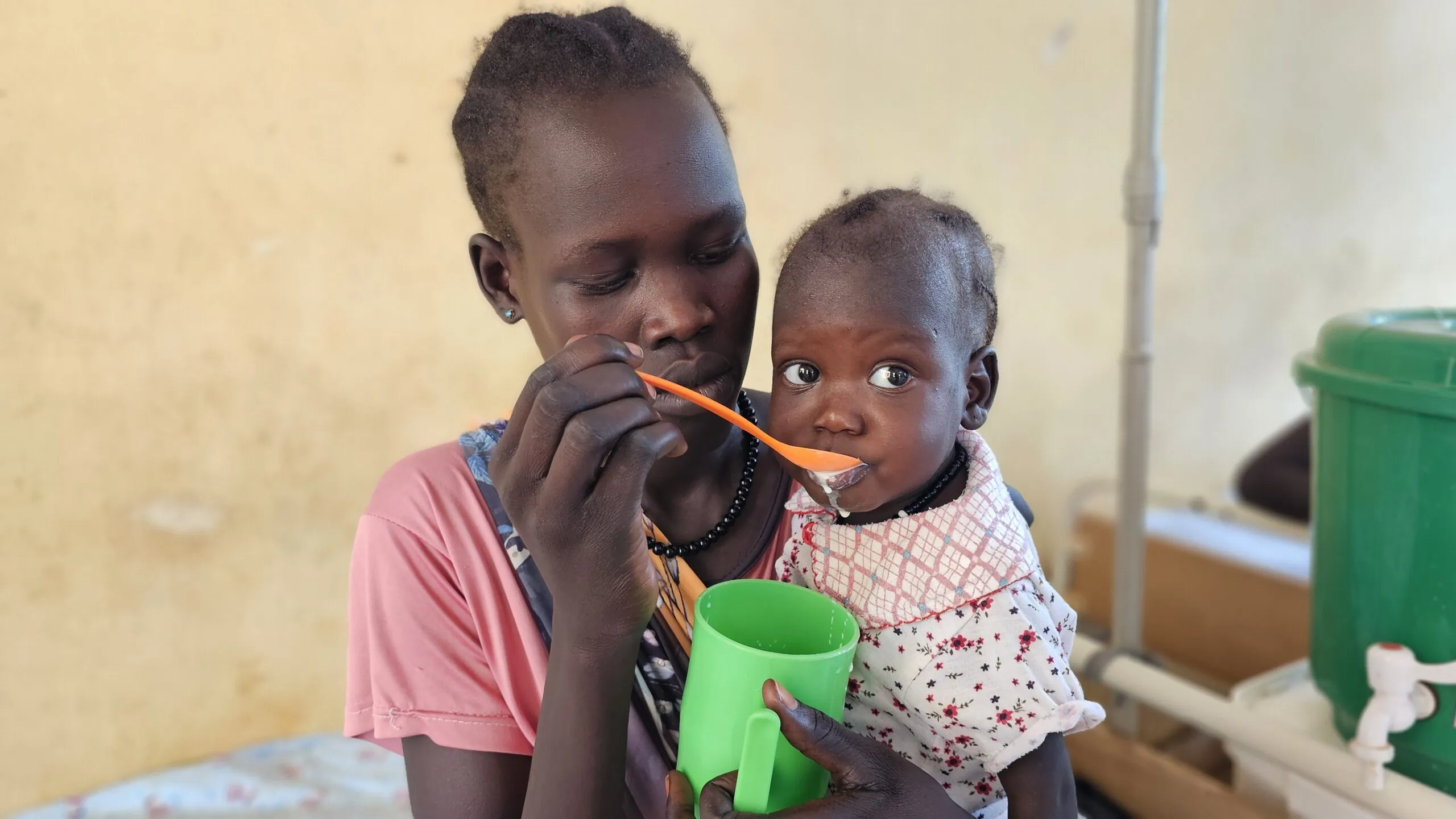 A mother holds her young daughter during nutrition treatment at a hospital in South Sudan.