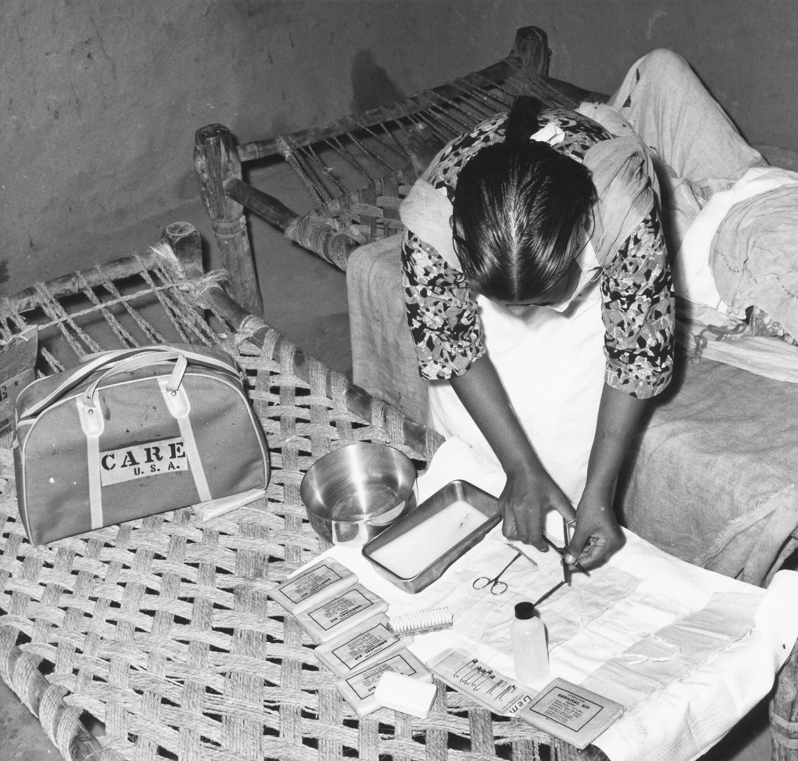 A woman opening-up a medical CARE PACKAGE and putting the medical instruments on a towel.