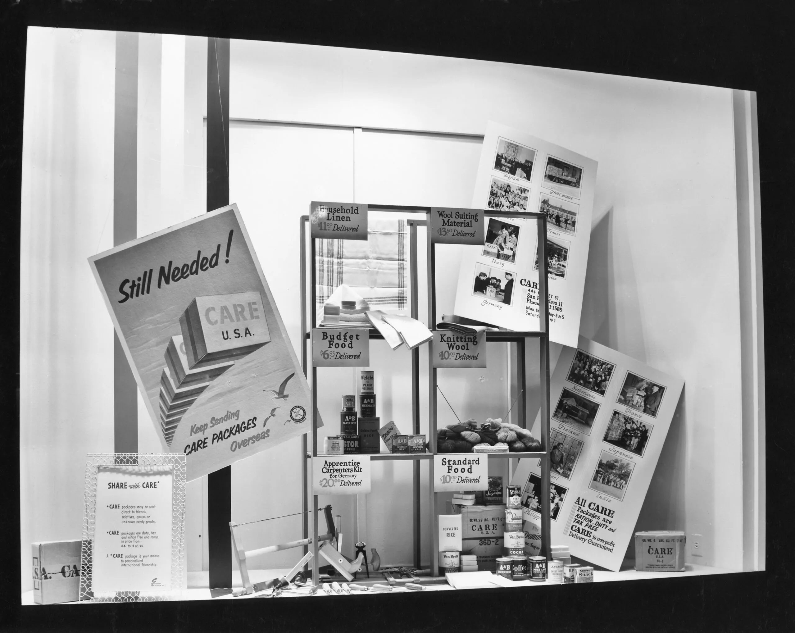 A historical image of a window display with CARE posters and items from a CARE PACKAGE.