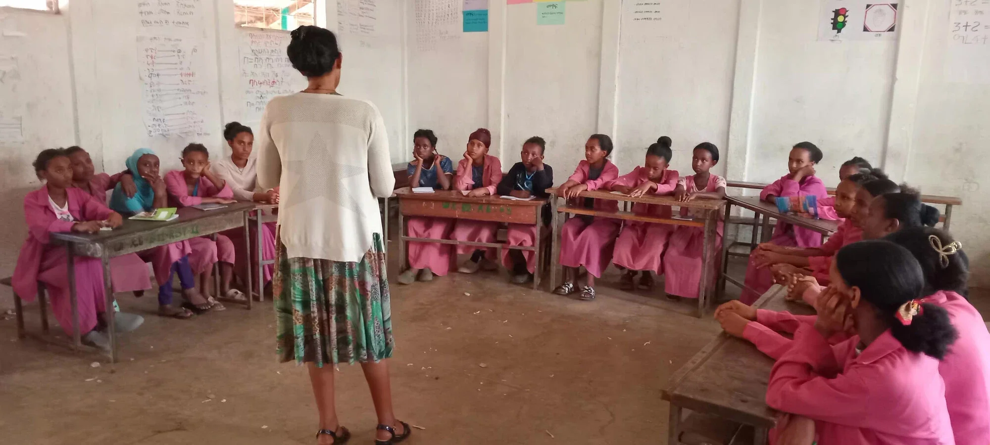 A health officer leads a session on menstrual hygiene and health for a group of schoolgirls in pink uniforms at Atse Sertse Dingle primary school in Ethiopia.