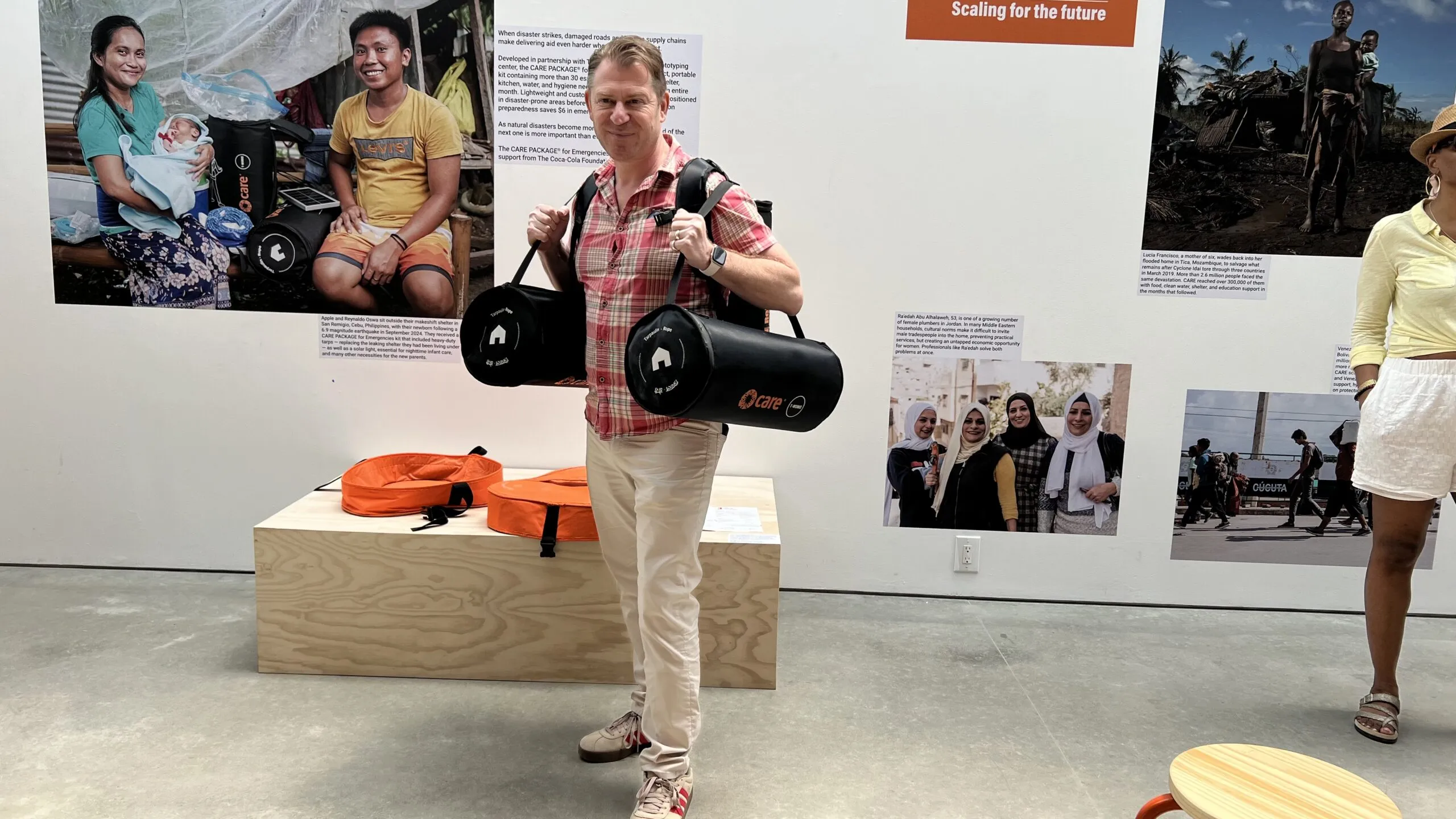 A man standing with bags on each shoulder.