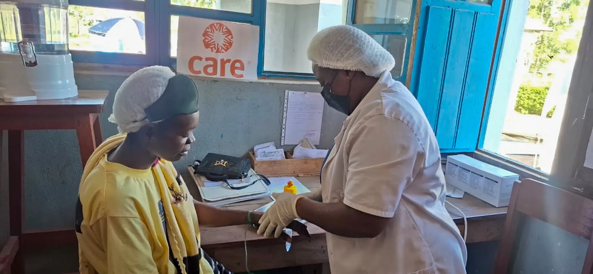 A nurse is checking a patient inside a small health clinic.