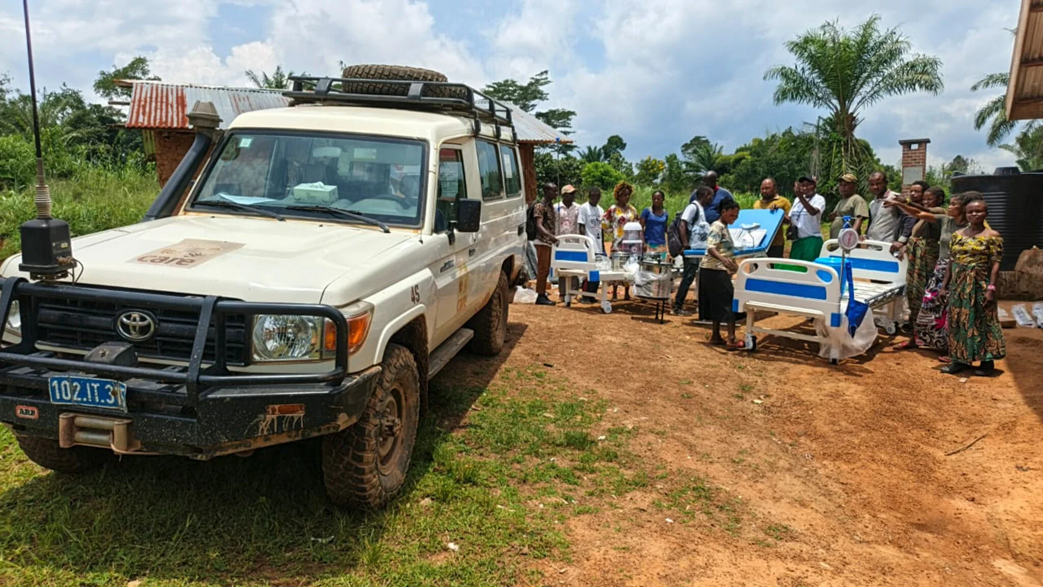 People unloading medical supplies and beds from a truck.