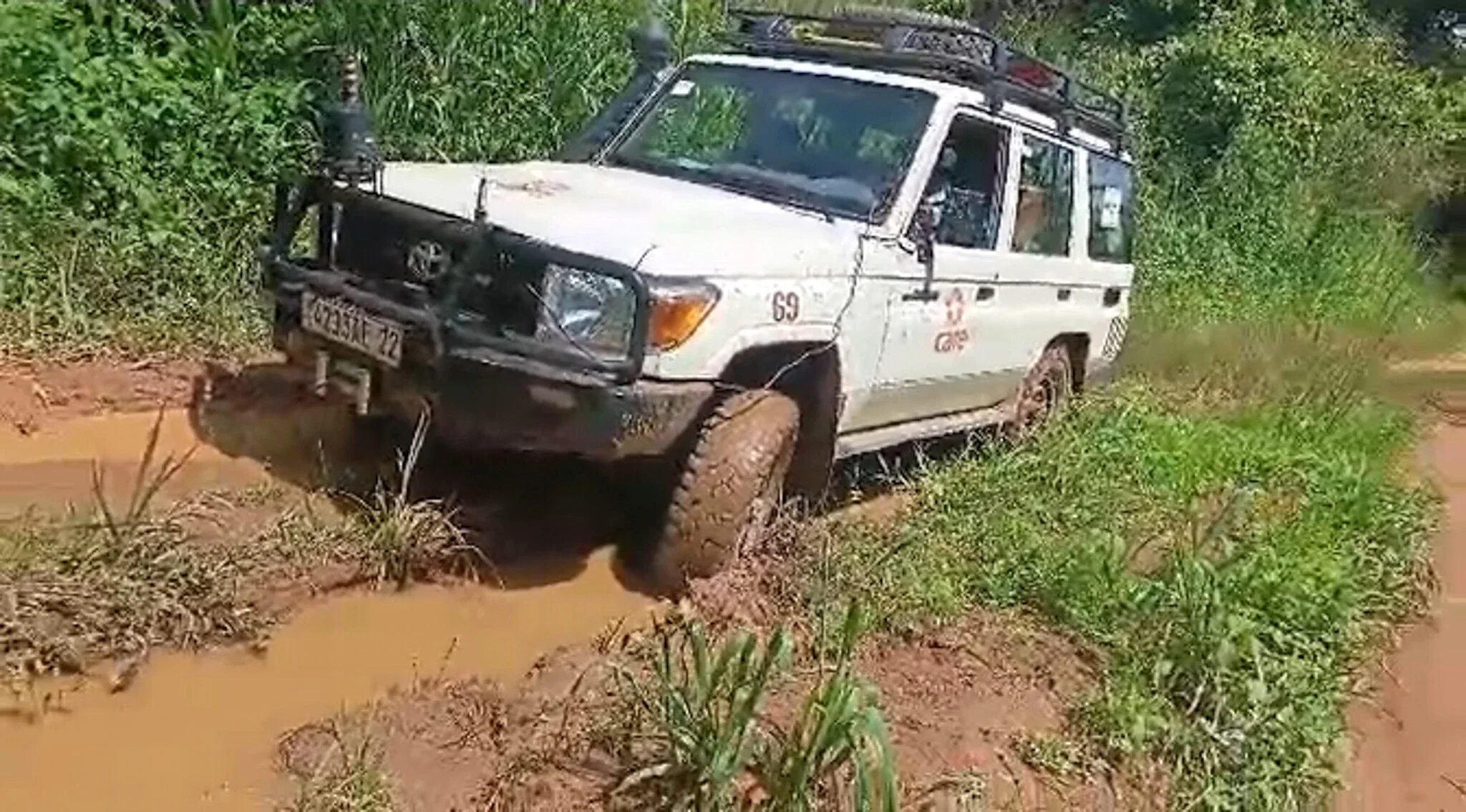 A truck seemingly with its tires stuck on a muddy road.