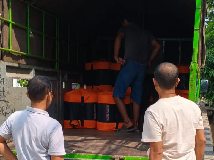 Men unloading emergency relief packages from truck after an earthquake struck Indonesia.