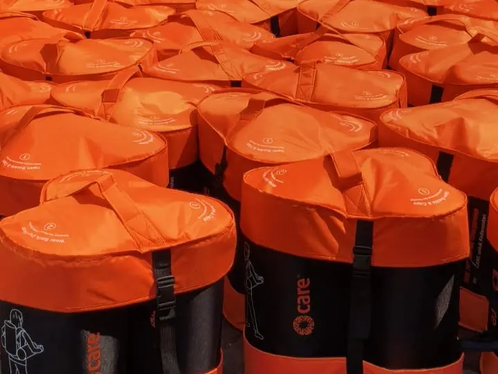 A group of CARE PACKAGE for Emergencies with bright orange lids.