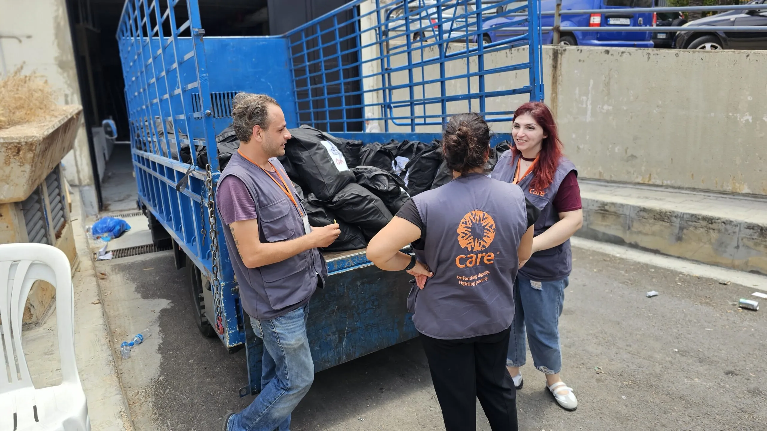 Three CARE humanitarian workers in Lebanon distribute dignity kits.
