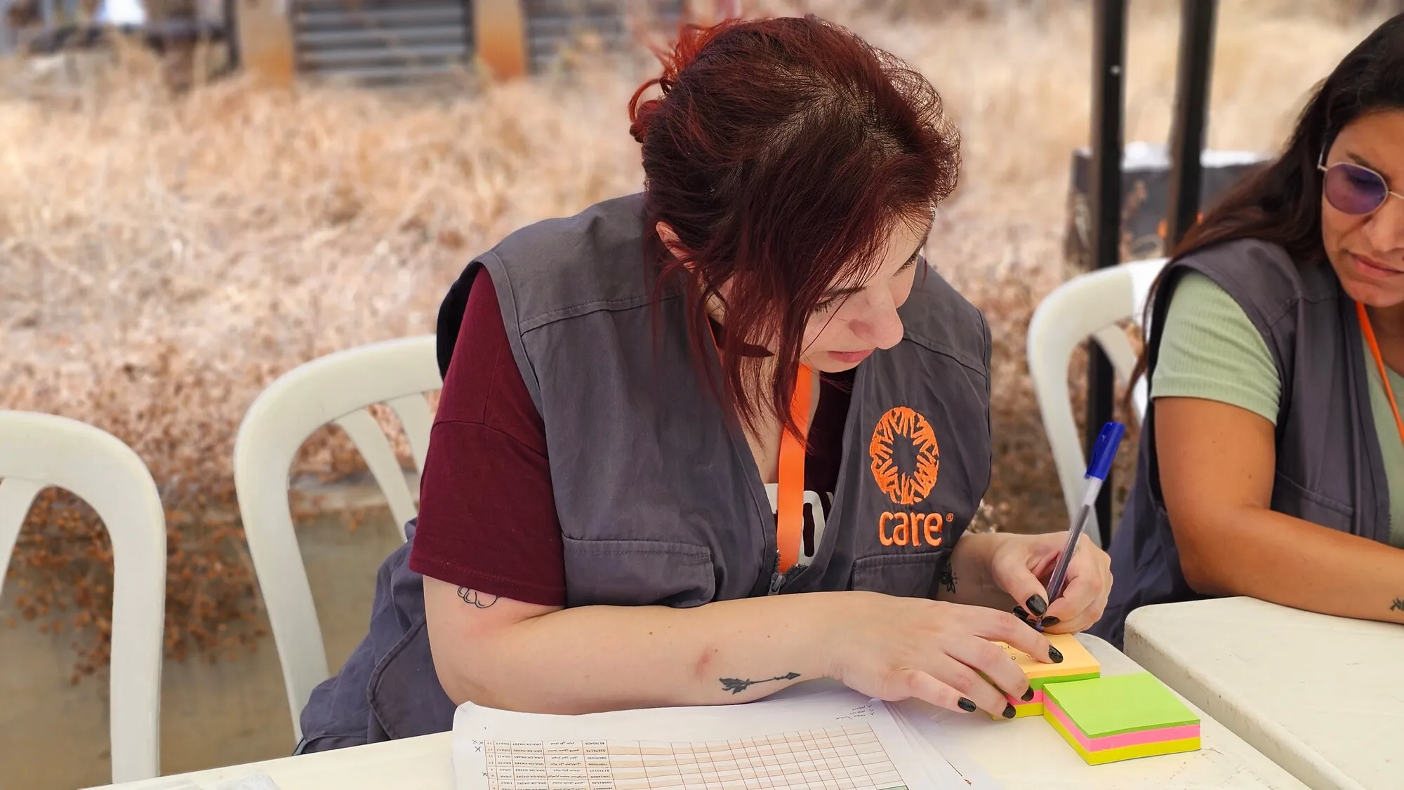 A woman humanitarian worker takes notes during a distribution event in Beirut, Lebanon.