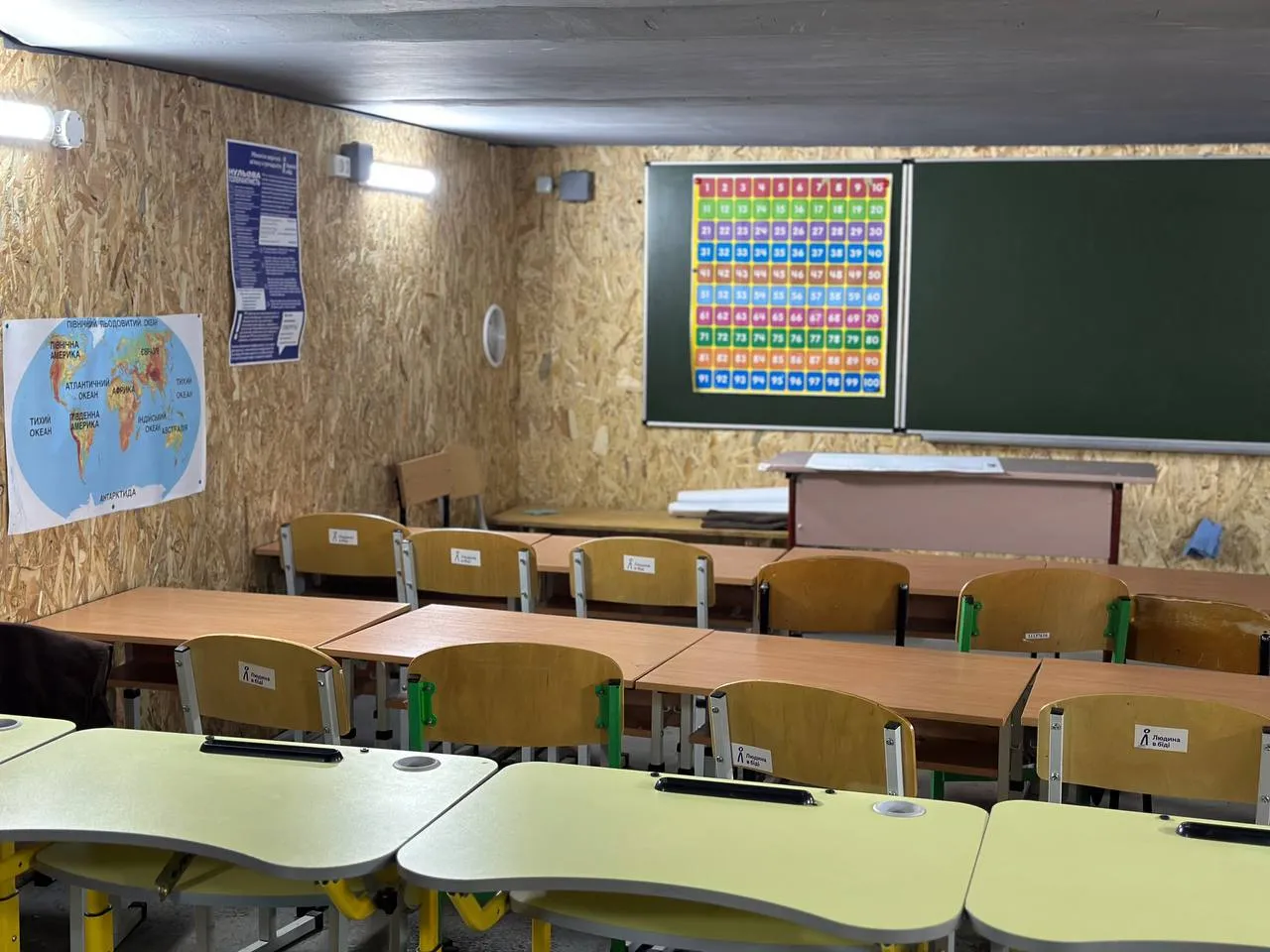 A makeshift classroom with wooden walls that was built in a shelter in Ukraine.