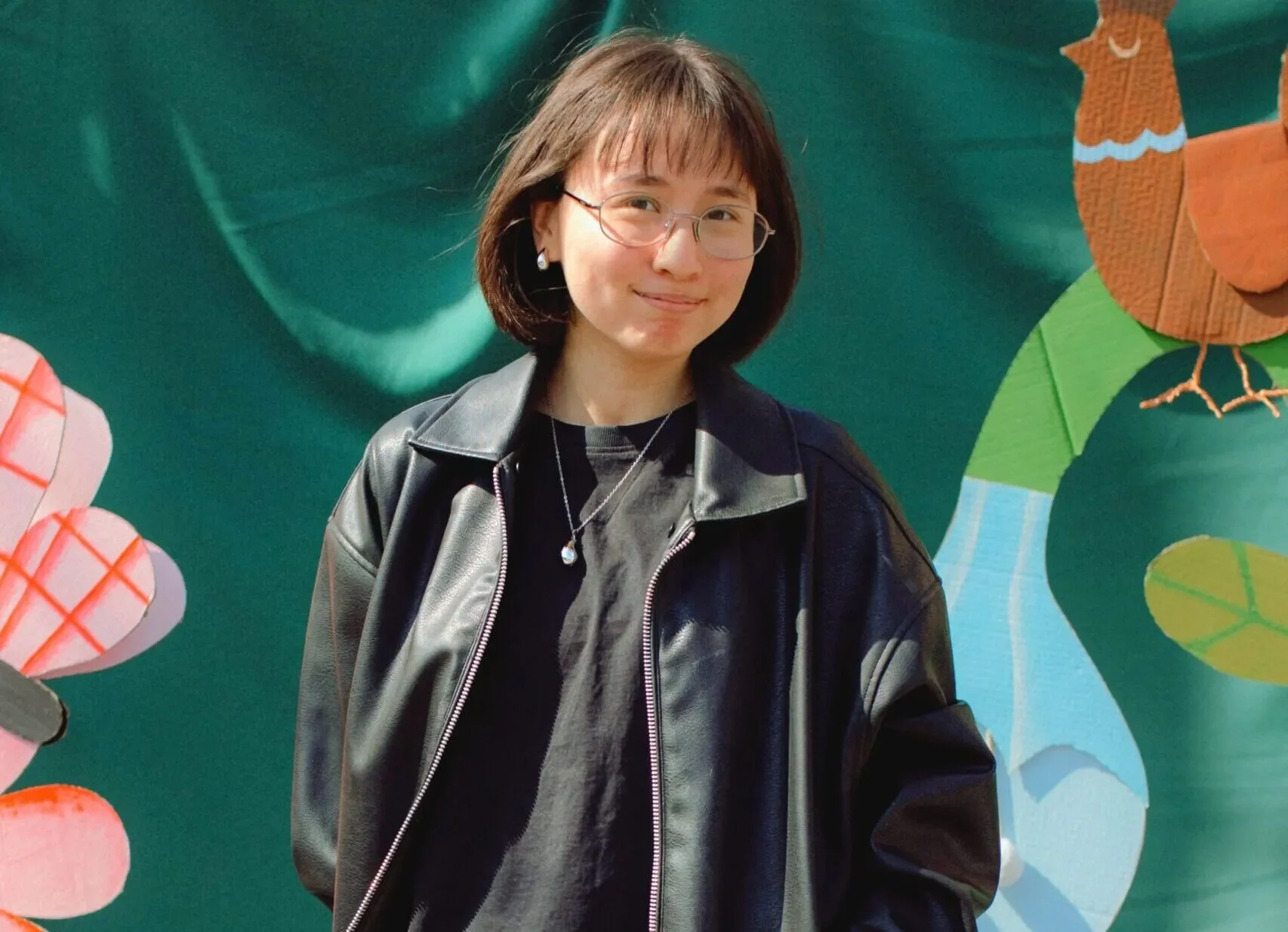 Svitlana stands outdoors in front of a colorful illustrated backdrop in Zaporizhzhia, Ukraine.