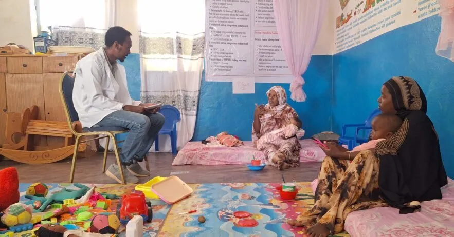 Health officer Zekarias Getachew talks with mothers about caring for children recovering from malnutrition.