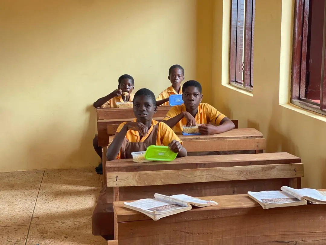 Students eating lunch in a classroom at school.