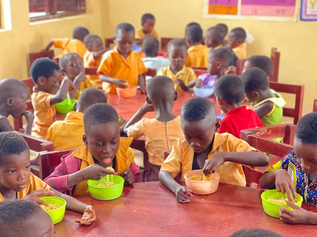 A group of students eat at round tables.